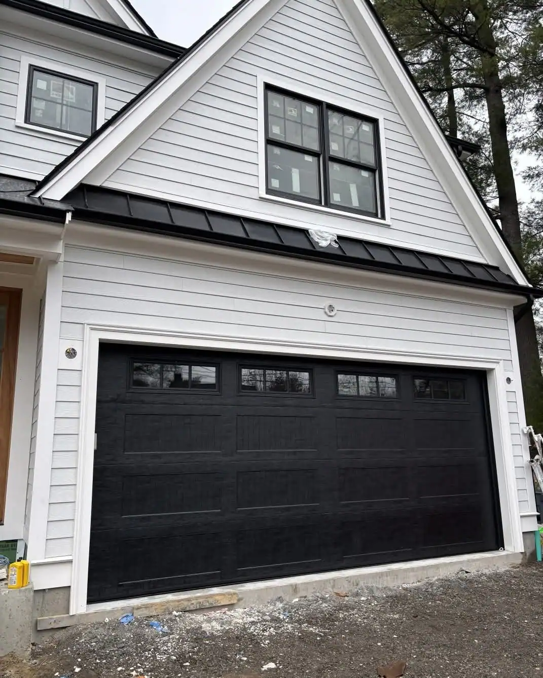 A black carriage-style door with top windows