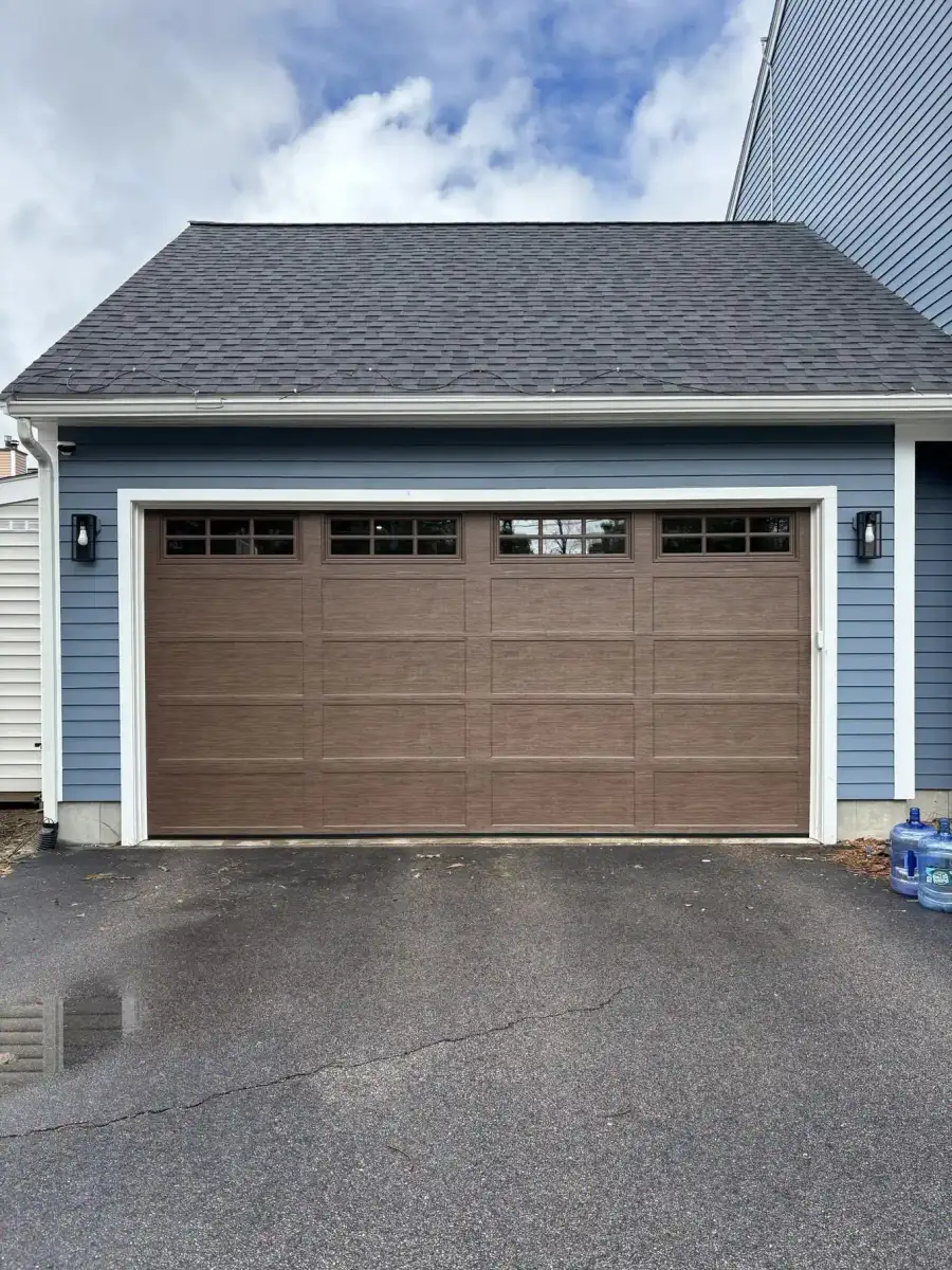 A brown wood-look double door on a blue-gray house