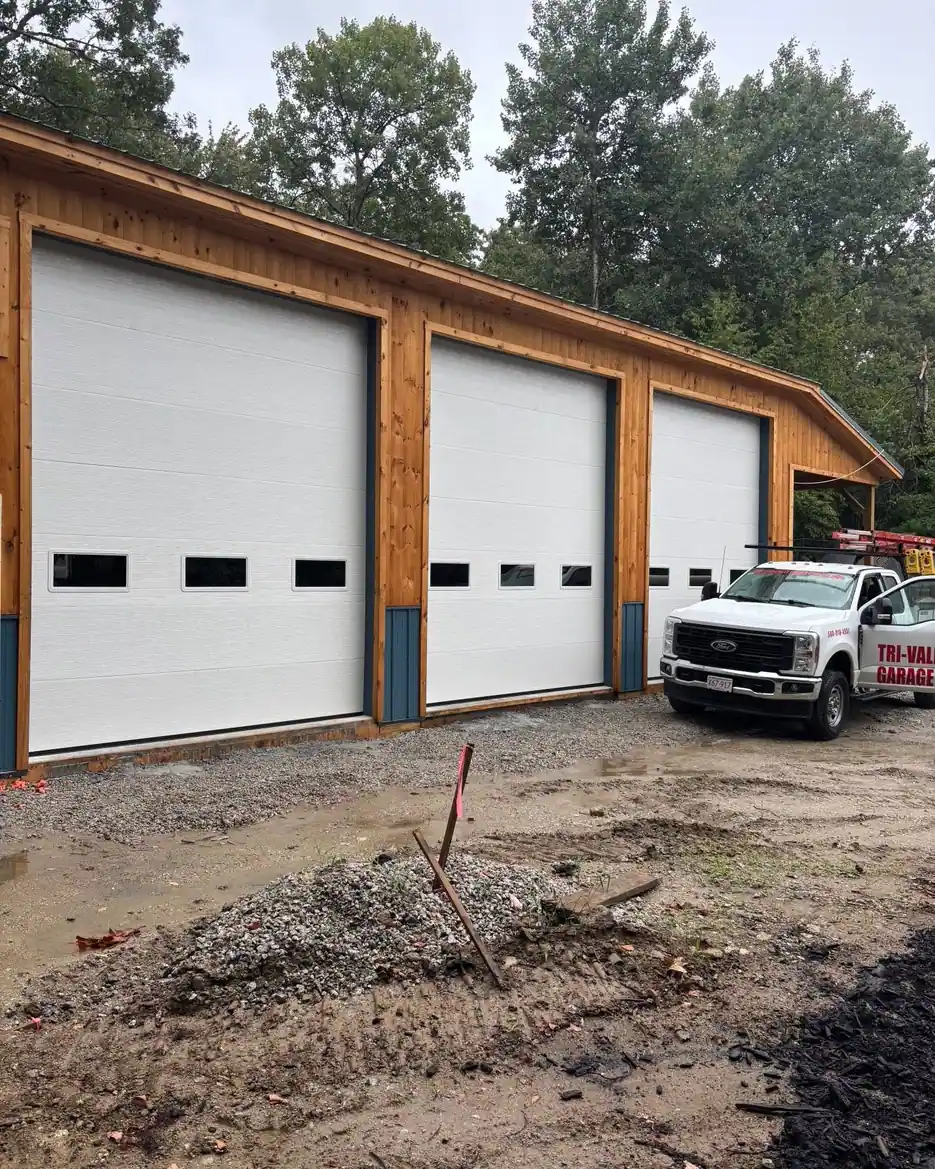 Three tall commercial doors on a new wood-framed building
