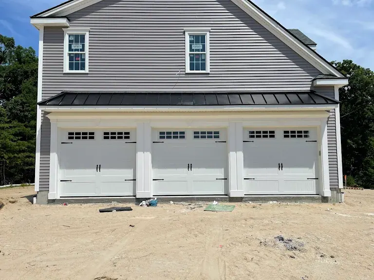 Three white carriage-style doors on a new construction home