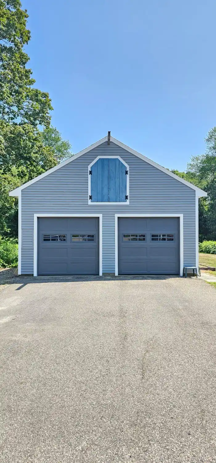 Two gray raised-panel doors on a blue house
